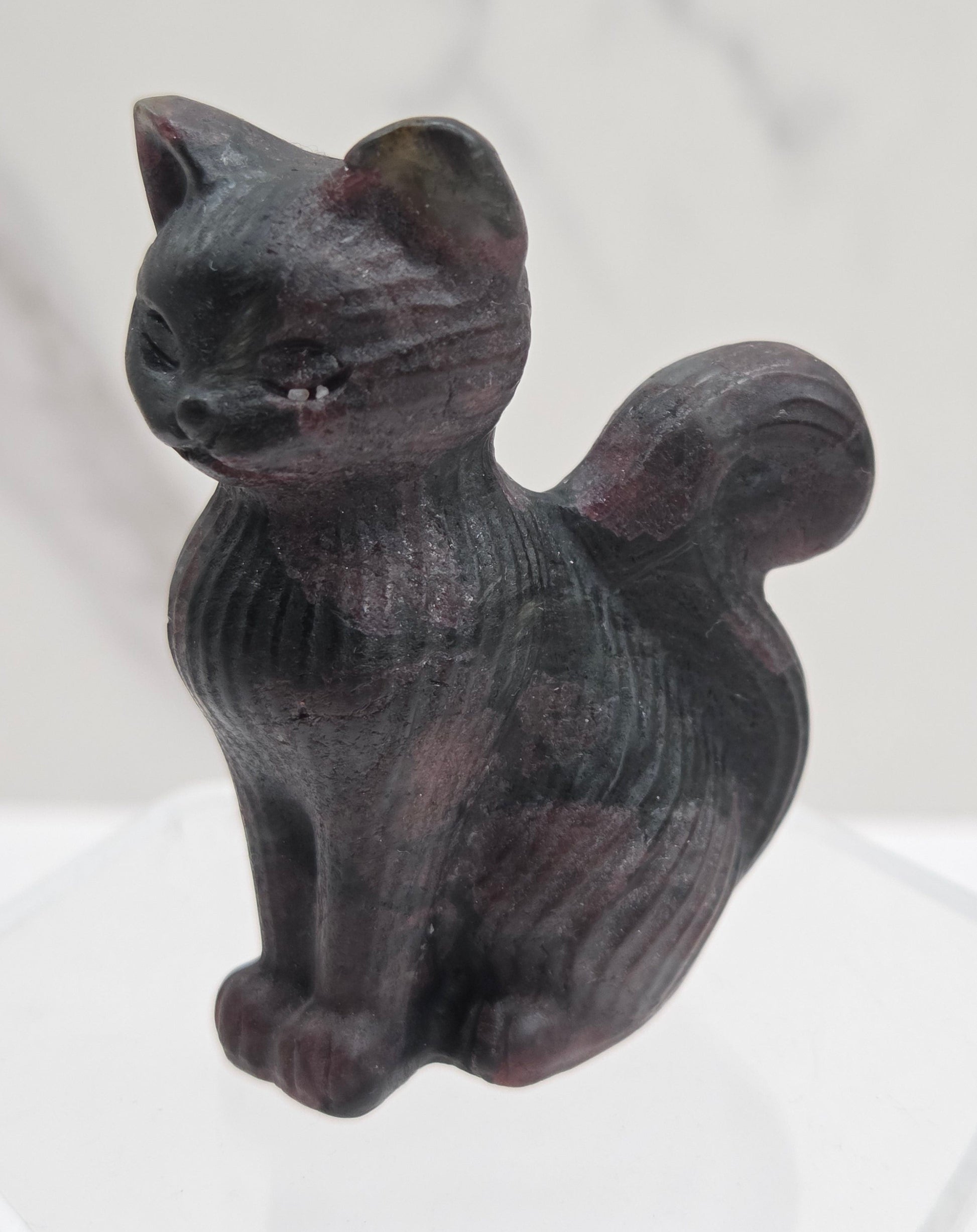 Black stone carving of a cat on a white background