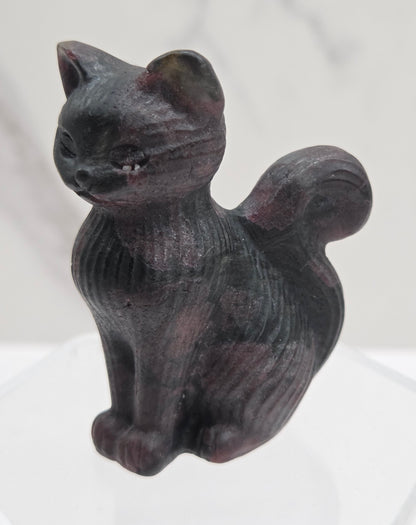 Black stone carving of a cat on a white background