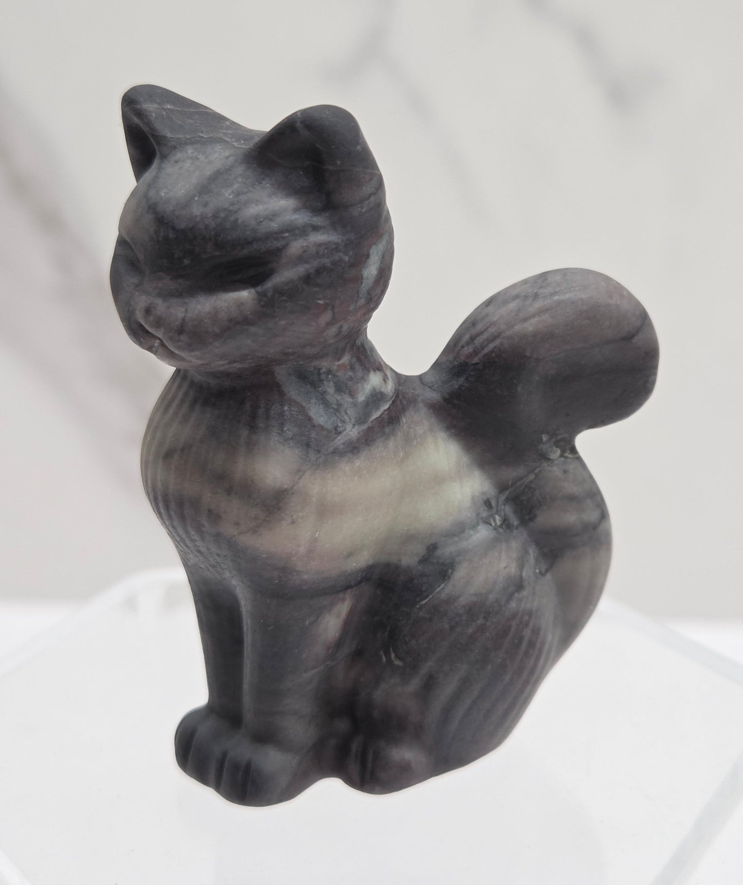 Gray stone sculpture of a cat on a white background