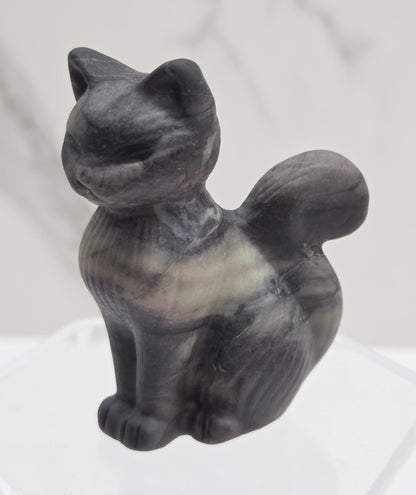 Gray stone sculpture of a cat on a white background