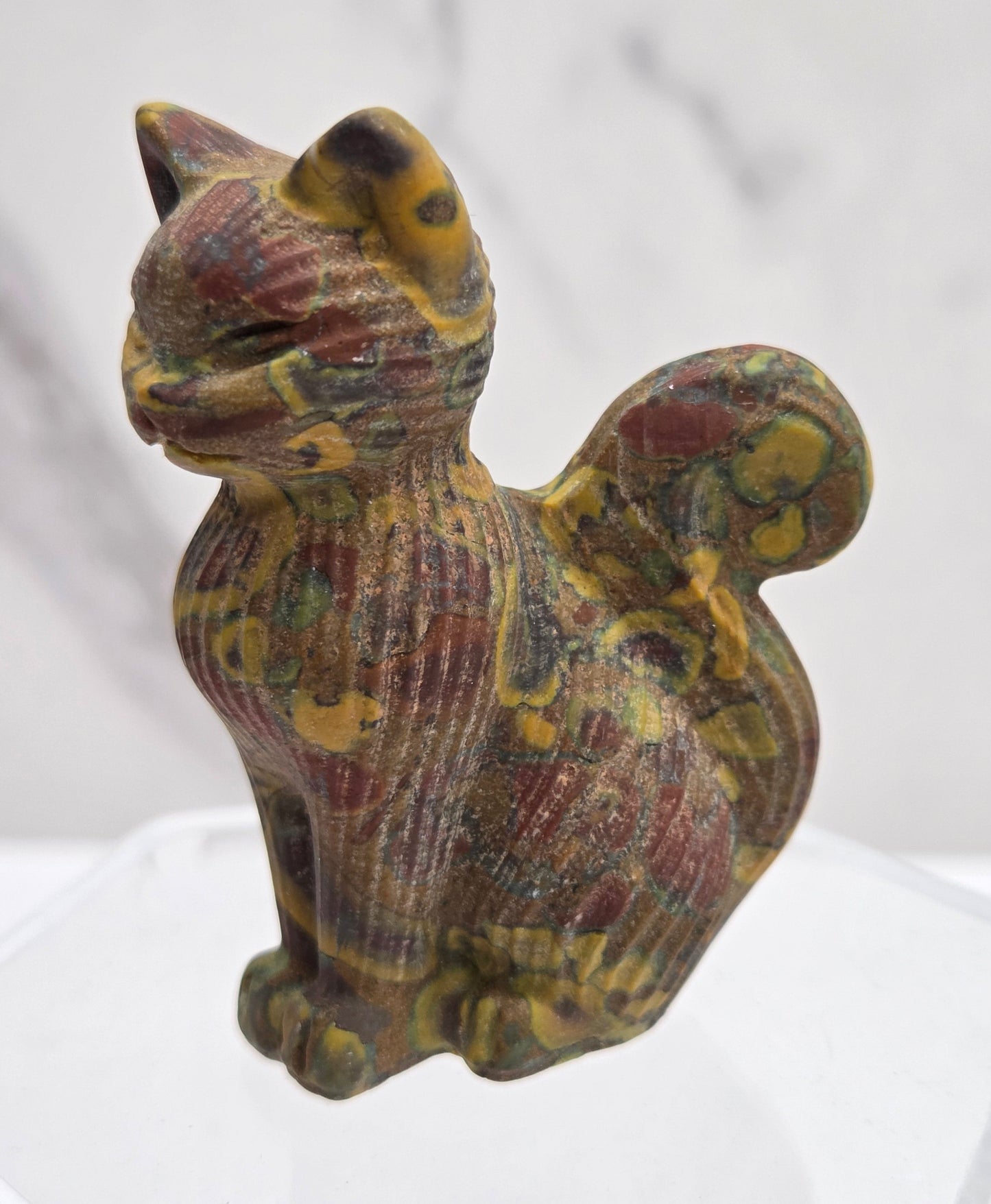 Decorative cat figurine with a shell pattern on a white background