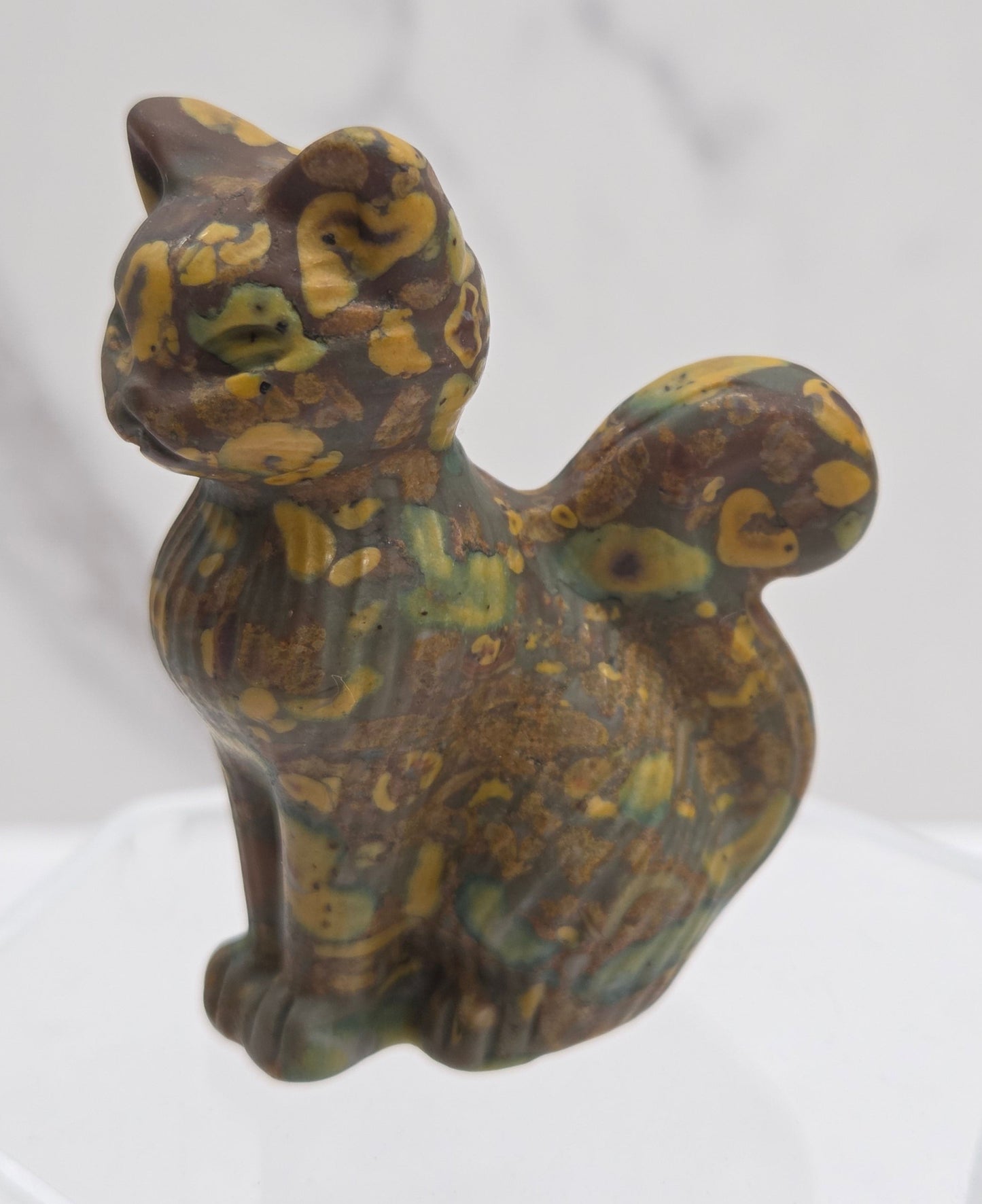 Crystal cat figurine with brown and yellow pattern on a white background