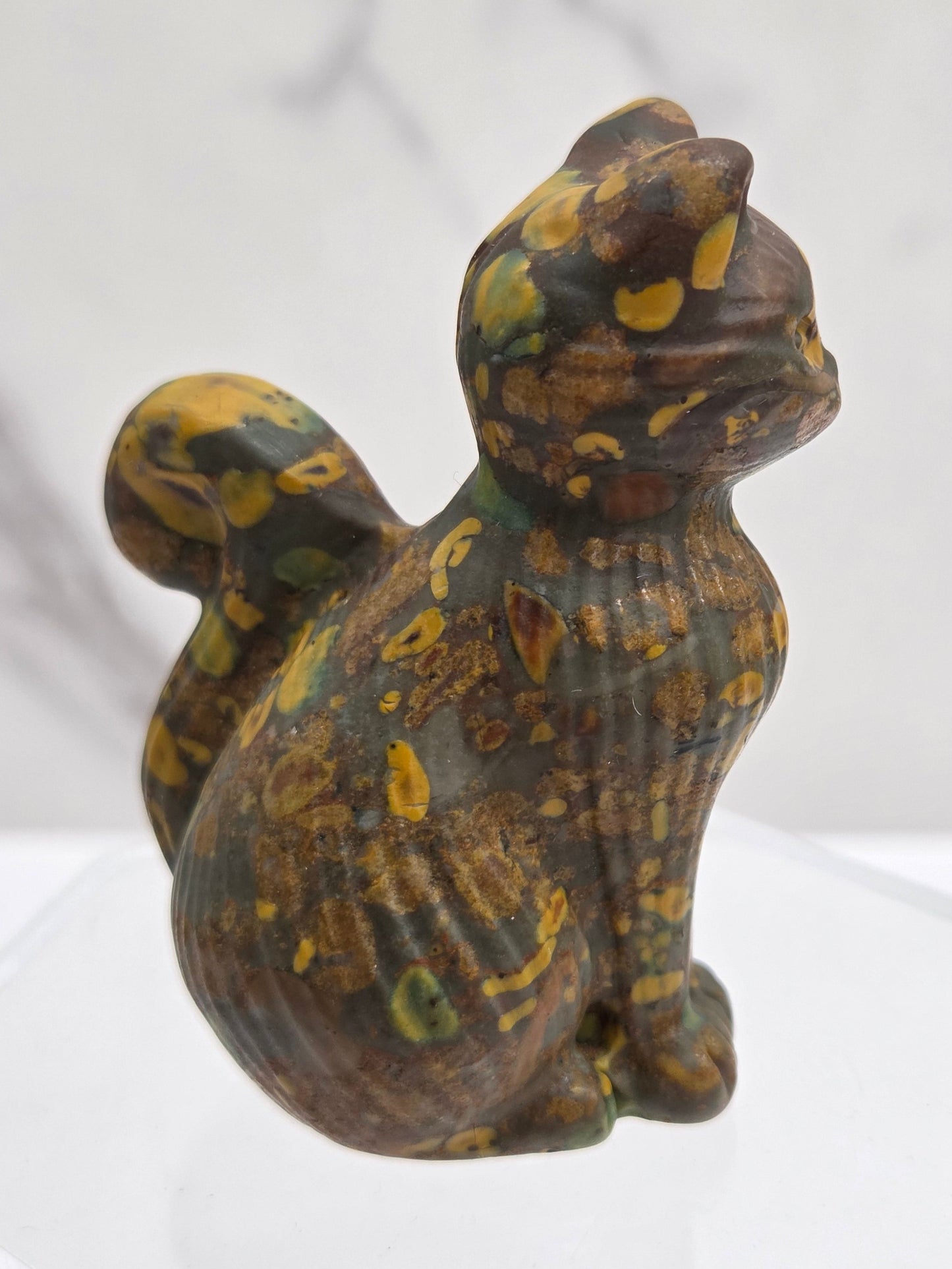 Crystal cat figurine with brown and yellow pattern on a white background