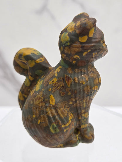 Crystal cat figurine with brown and yellow pattern on a white background