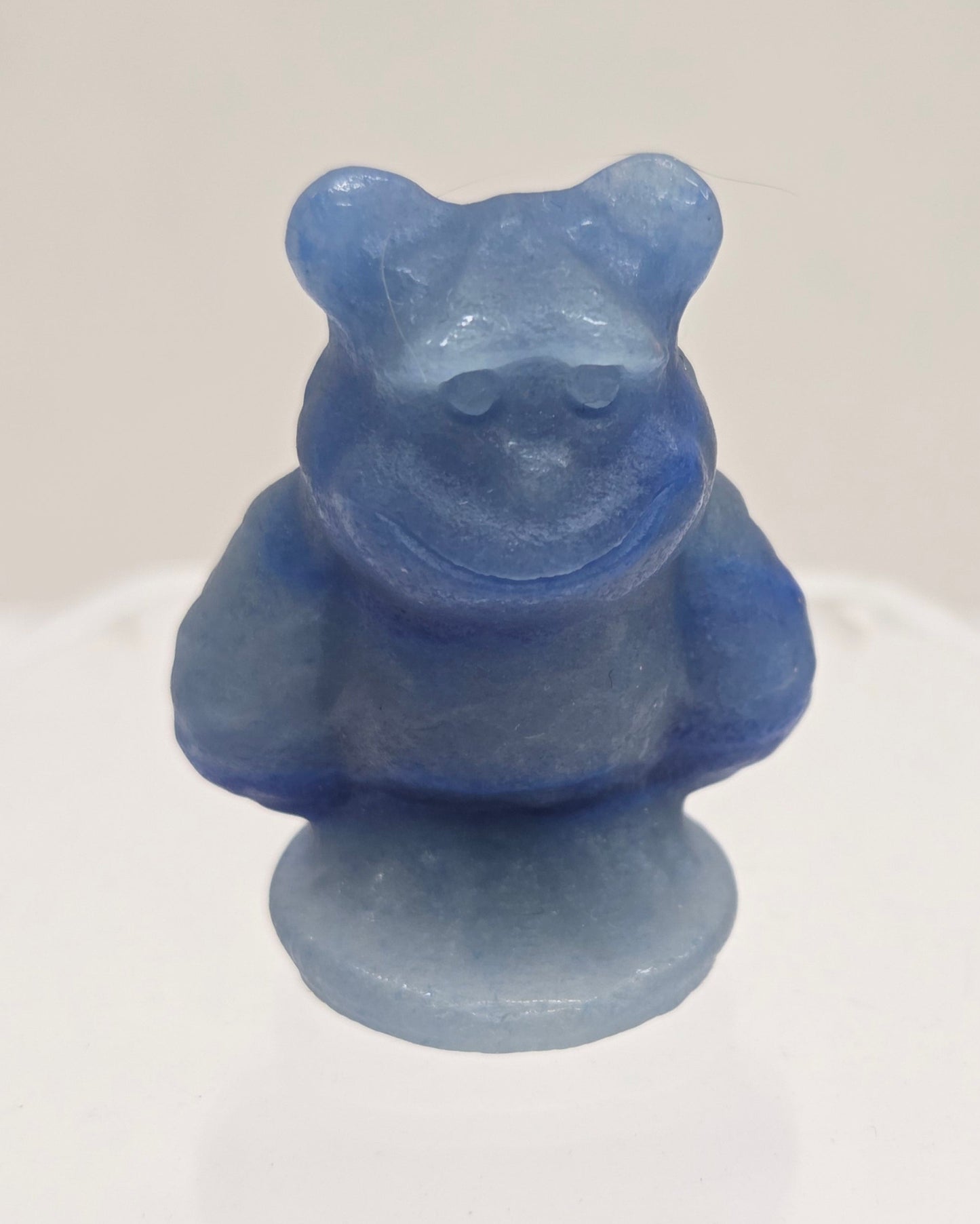 Sully carving, from Monsters Inc. movie, made of Blue Aventurine on a white surface with a marble background.