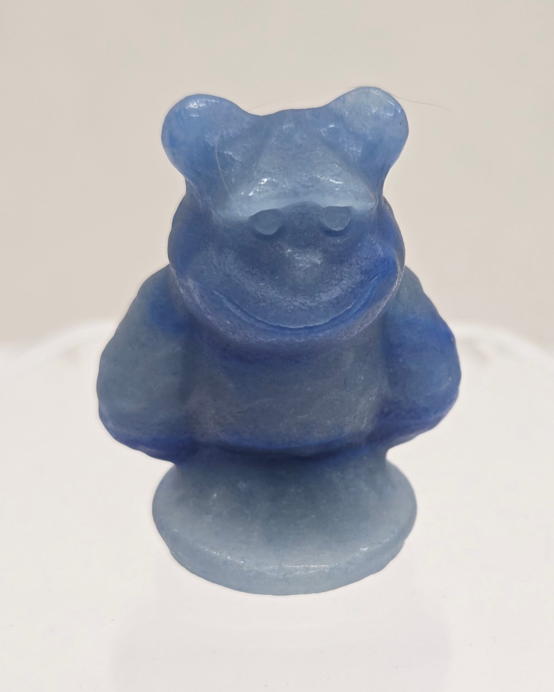 Sully carving, from Monsters Inc. movie, made of Blue Aventurine on a white surface with a marble background.