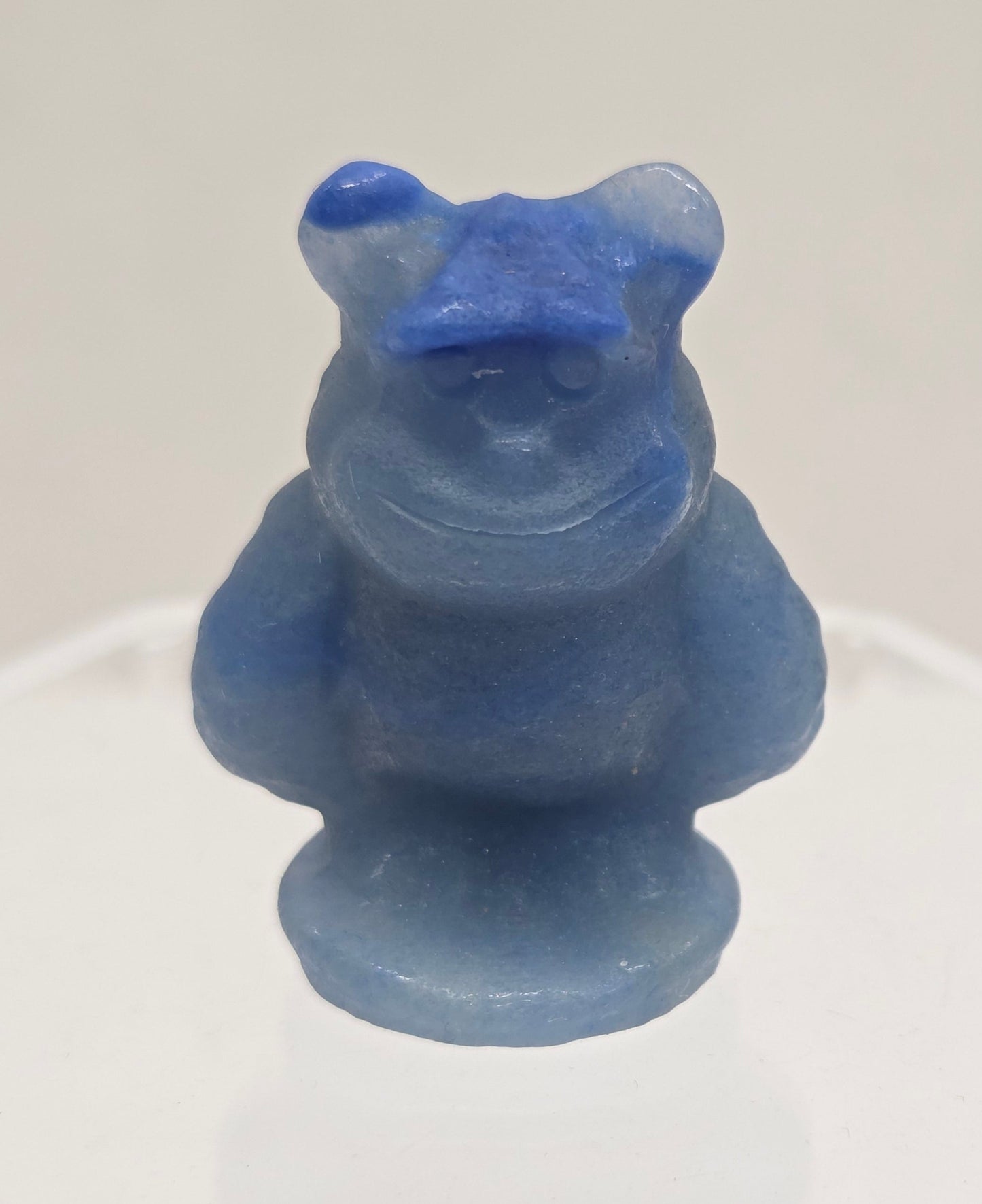 Sully carving, from Monsters Inc. movie, made of Blue Aventurine on a white surface with a marble background.