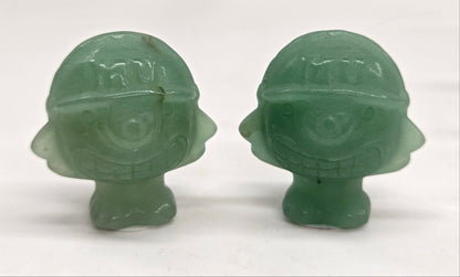 Two Green Aventurine Mike Wazowski  characters, for Monsters Inc., with helmets on a white background