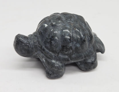 Larvikite turtle figurine against a white background.