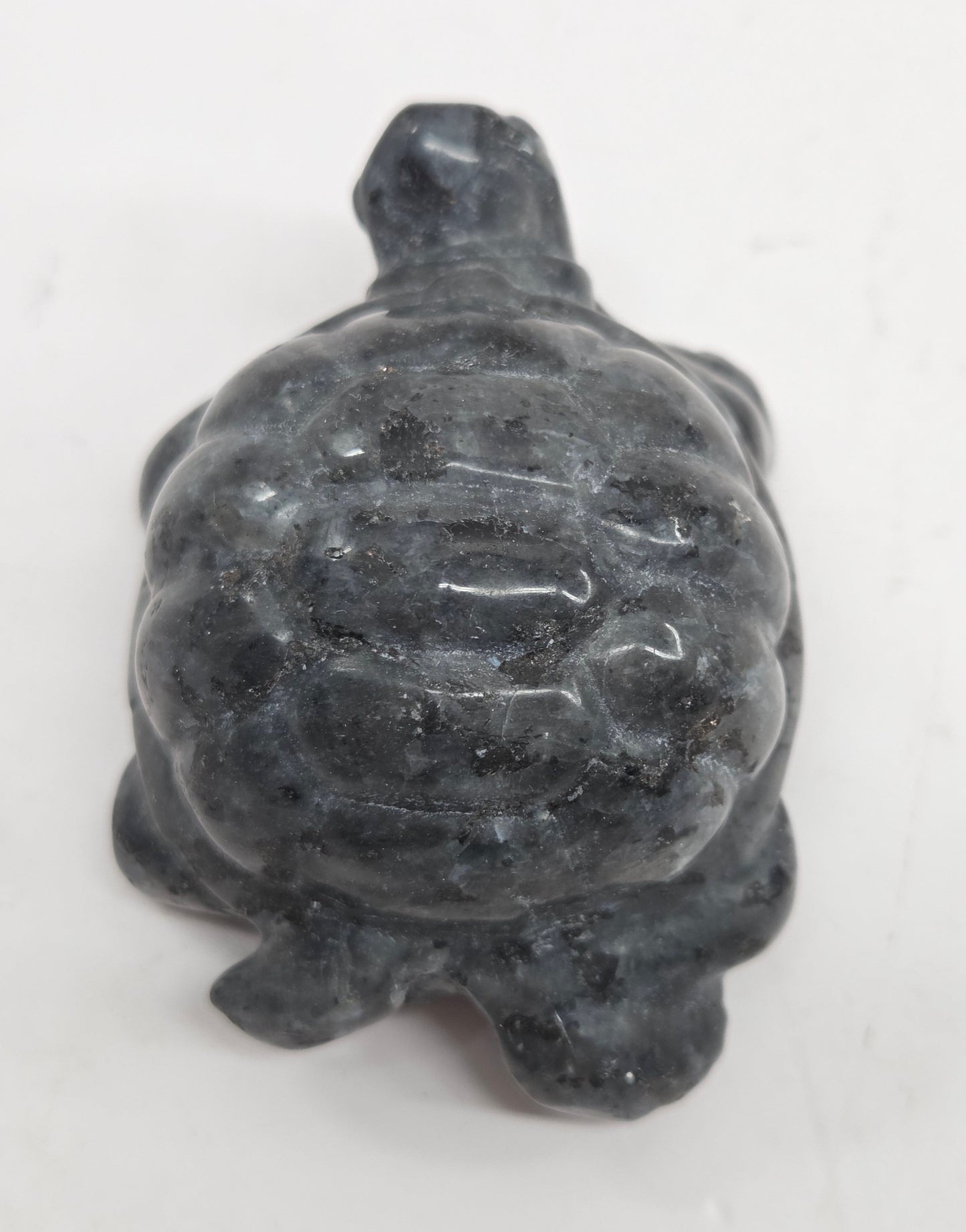 Larvikite turtle figurine against a white background.