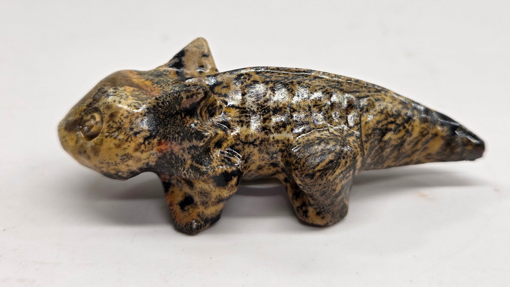Axolotl-shaped sculptures in Picture Jasper with yellow and brown coloring on a white background