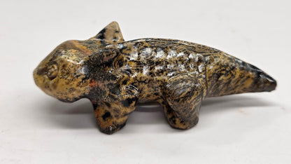 Axolotl-shaped sculptures in Picture Jasper with yellow and brown coloring on a white background
