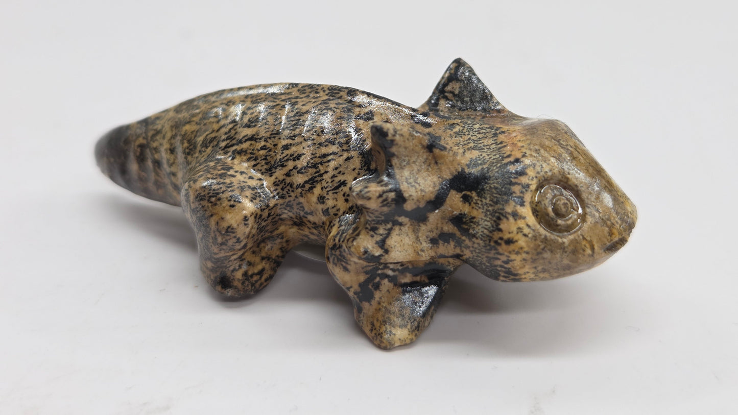 Axolotl-shaped sculptures in Picture Jasper with yellow and brown coloring on a white background