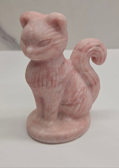 Crystal cat figurine made of Pink Opal on a white background