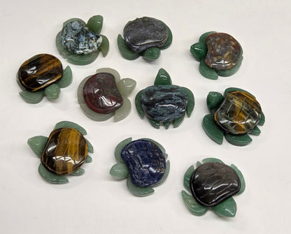 Collection of Jade turtle figurines with various colored shells on a white background