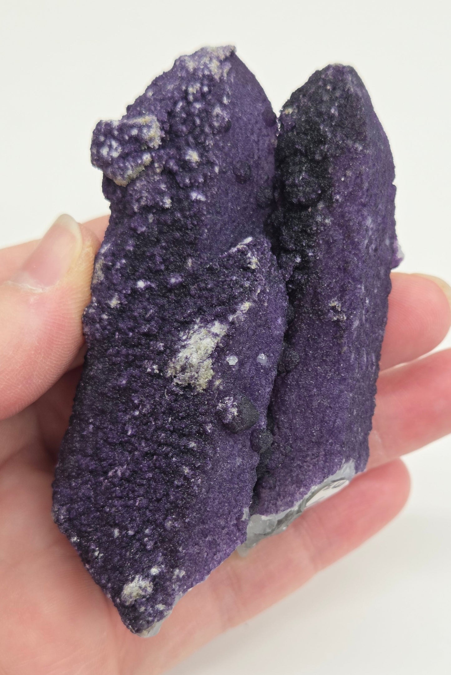 A collection of purple fluorite covered quartz points