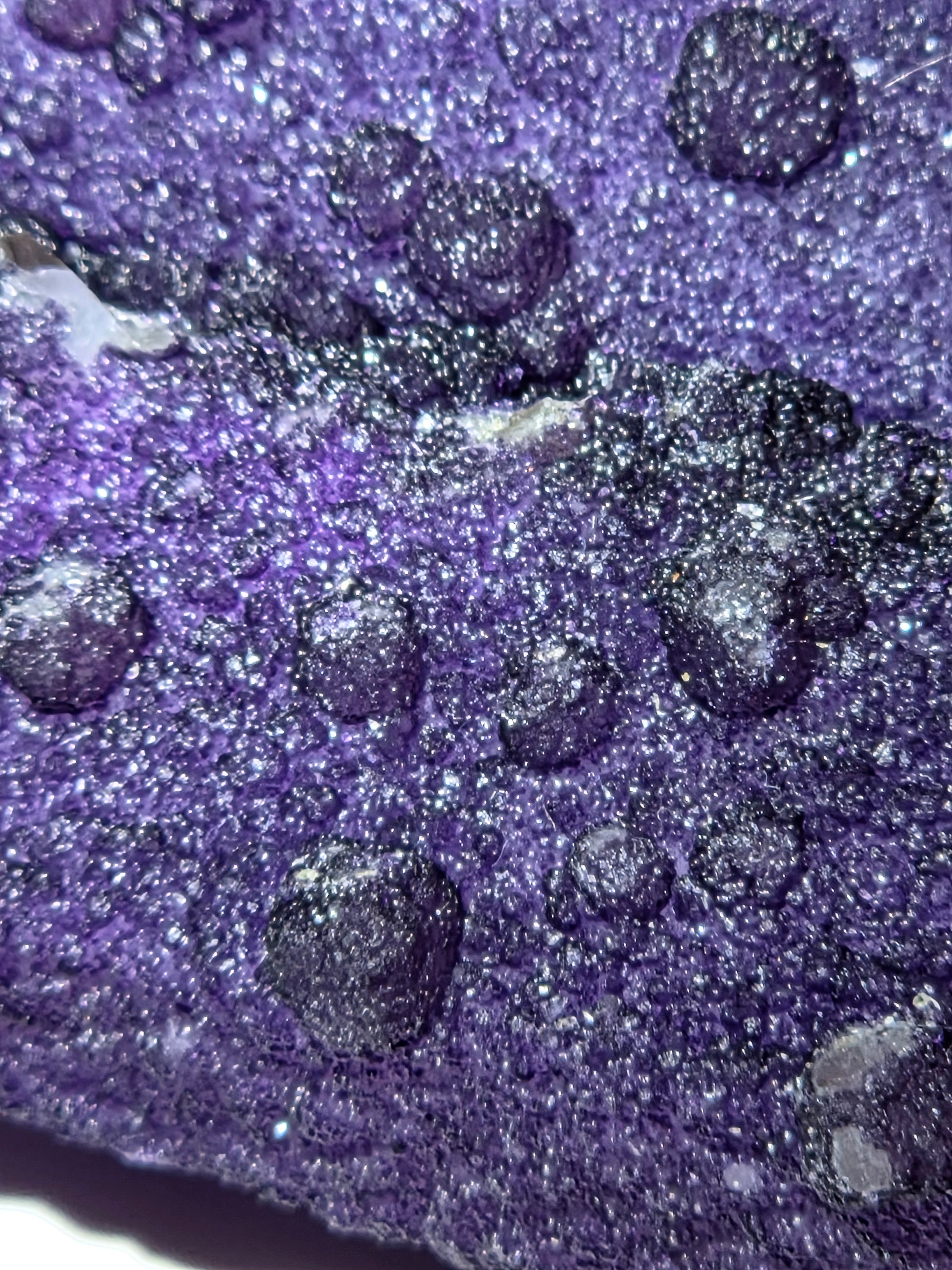 A close-up of purple fluorite covered quartz points