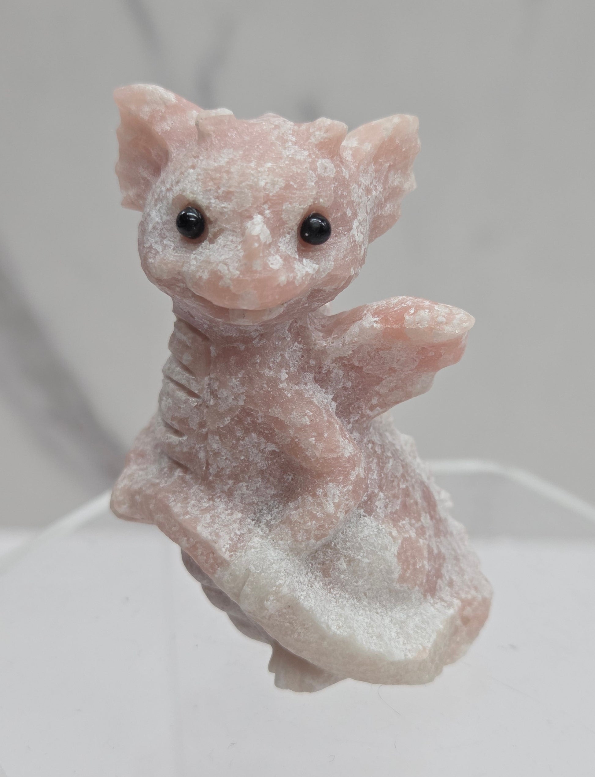 Small pink dragon-shaped object on a white background