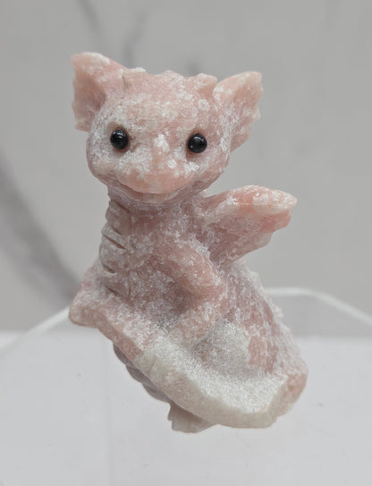 Small pink dragon-shaped object on a white background