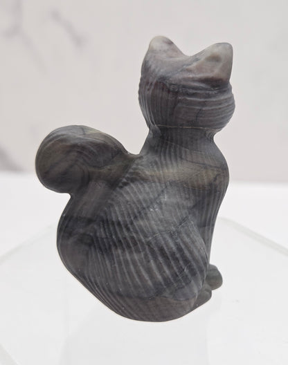 Gray stone sculpture of a cat on a white background