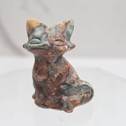 Maligano Jasper fox carving with grey, yellow and red coloring on a white background