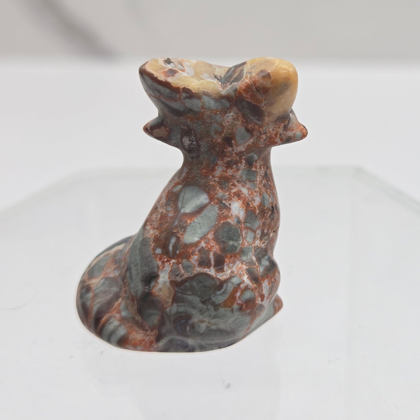 Maligano Jasper fox carving with grey, yellow and red coloring on a white background