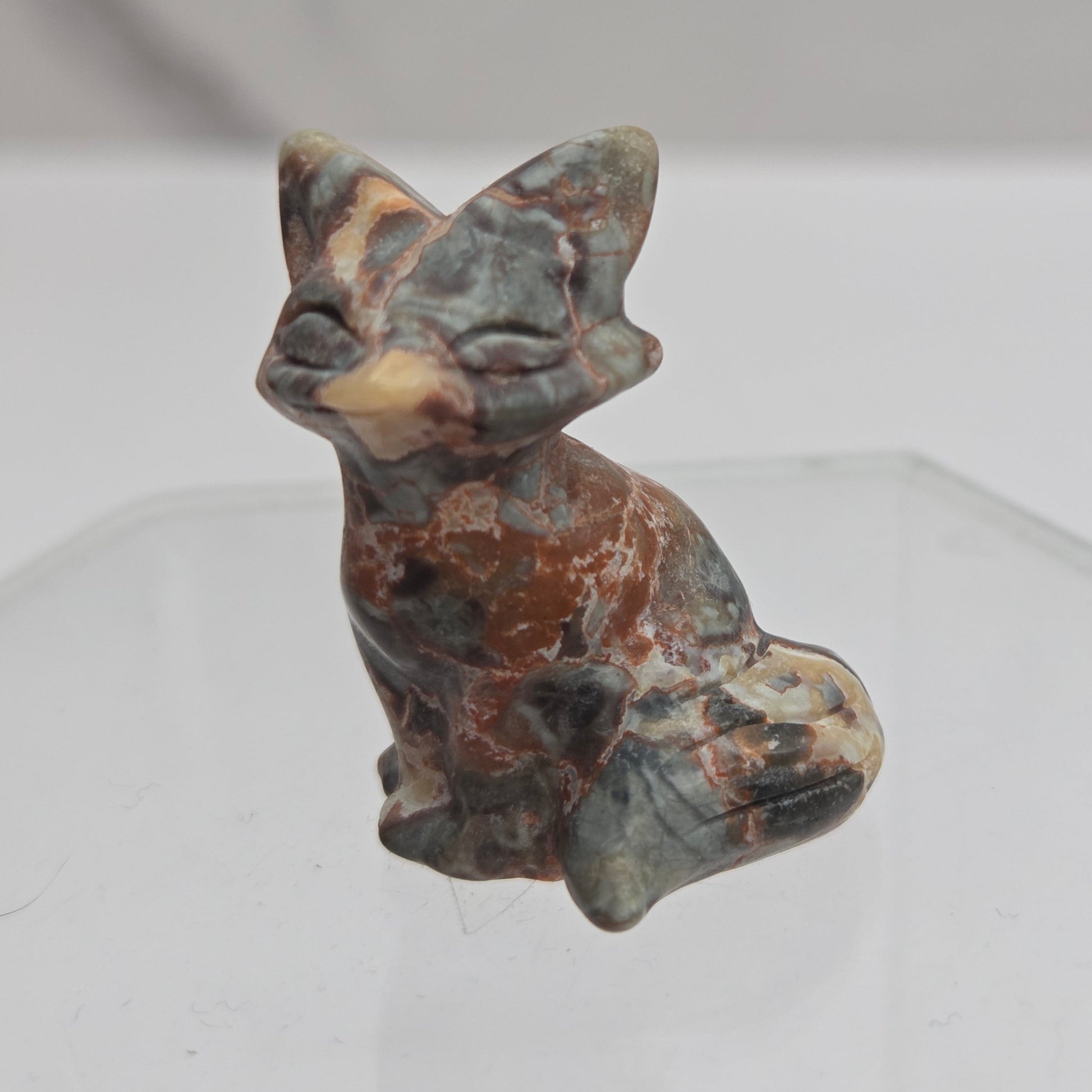 Money Agate fox carving with grey, yellow and red coloring on a white background