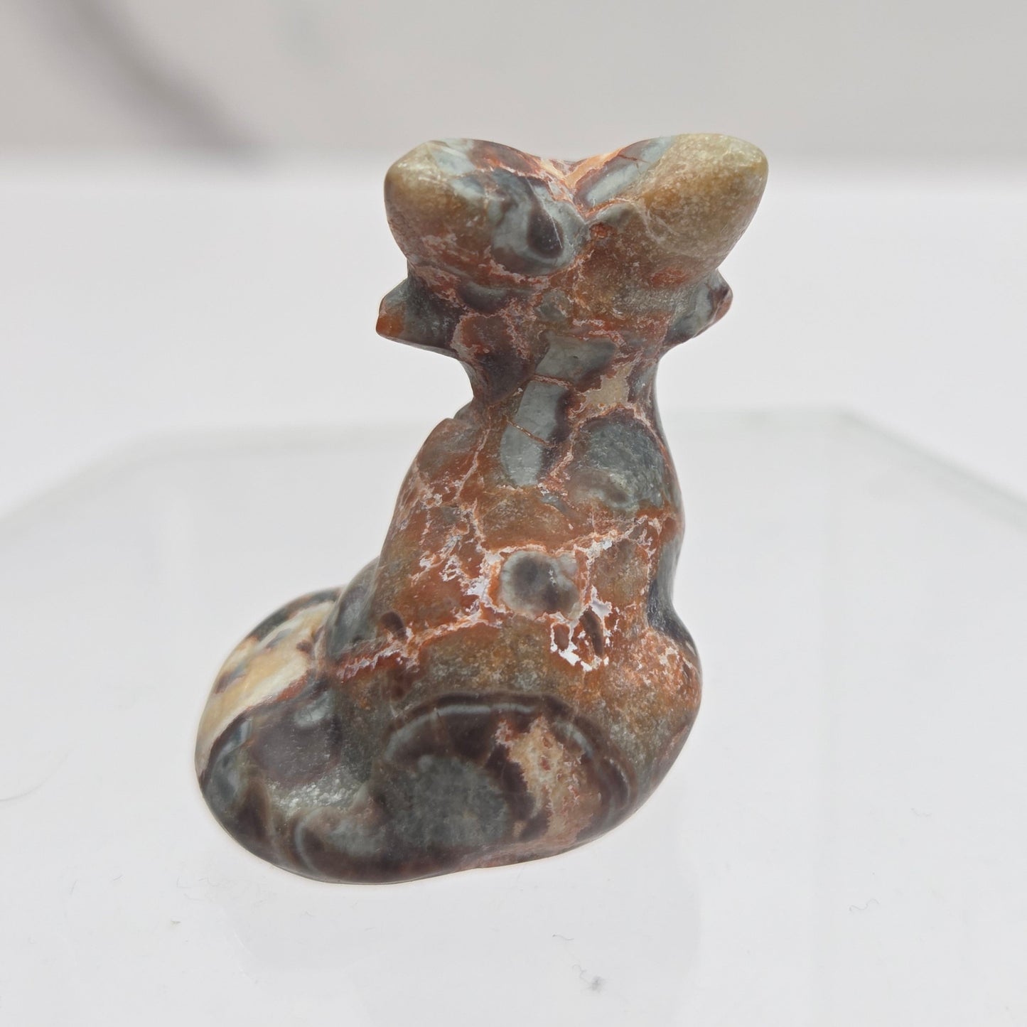 Money Agate fox carving with grey, yellow and red coloring on a white background