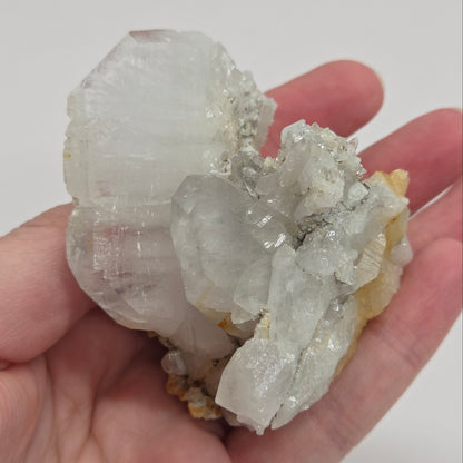 A clear quartz crystal with a white thread-like line running through it, showcasing the properties of Faden Quartz.