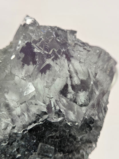 Close-up of a crystal or mineral sample on a light background