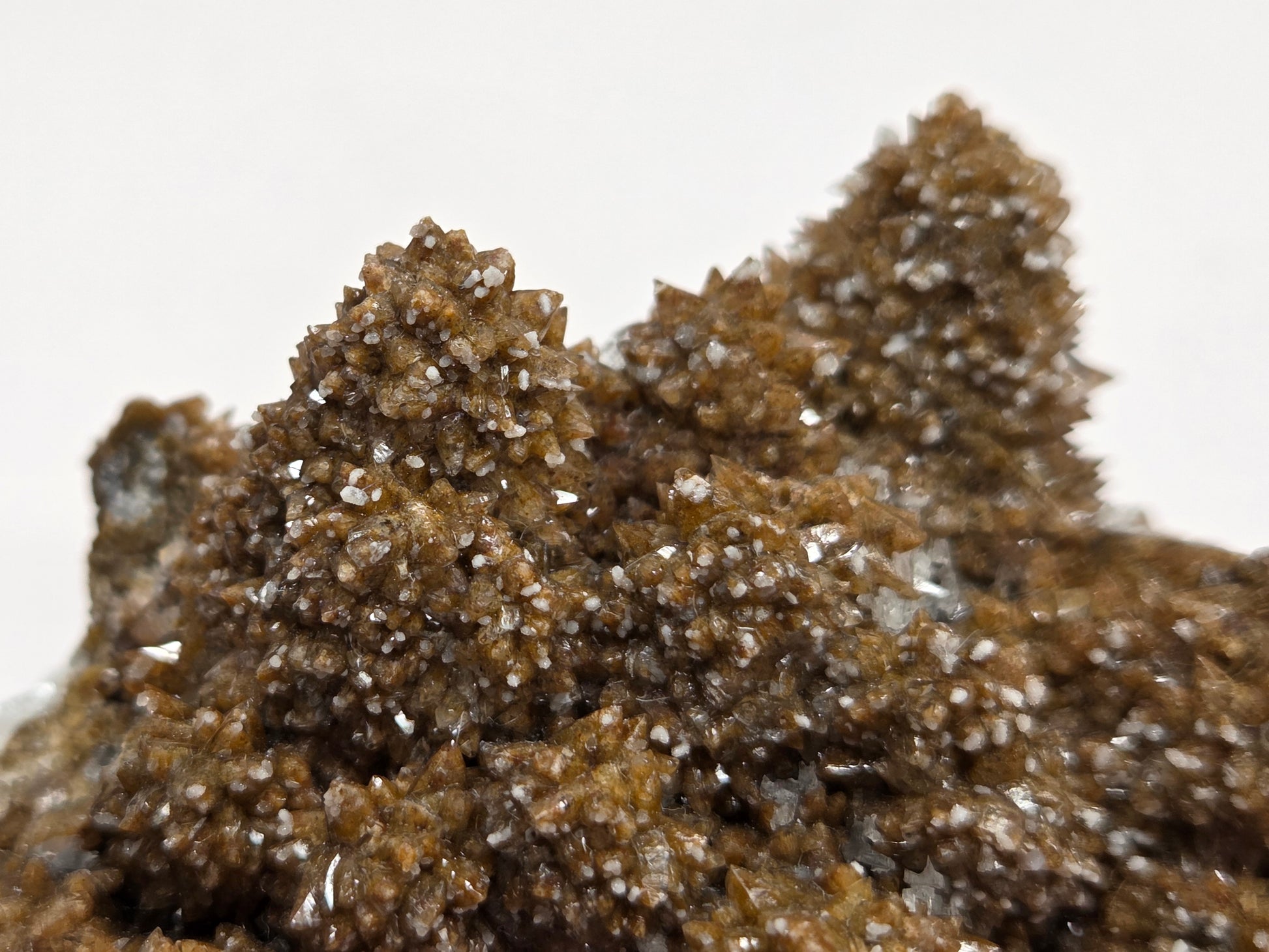 Close-up of a brown mineral sample with crystalline structure on a white background