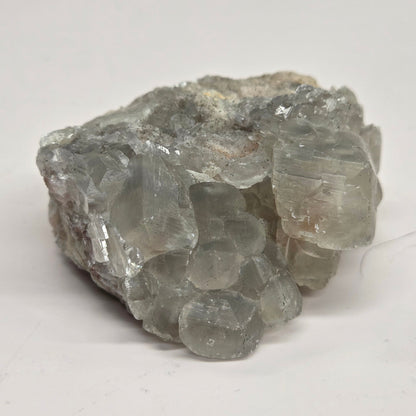 A rough, unpolished Money Calcite mineral from Hubei, China, with a translucent appearance and crystal-like formations.