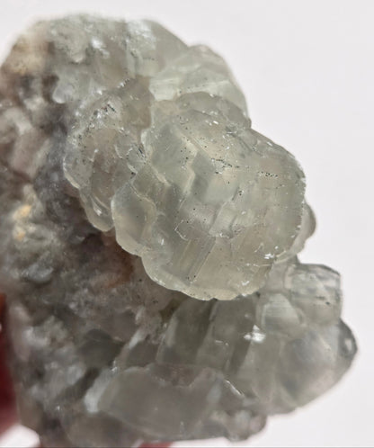A rough, unpolished Money Calcite mineral from Hubei, China, with a translucent appearance and crystal-like formations.