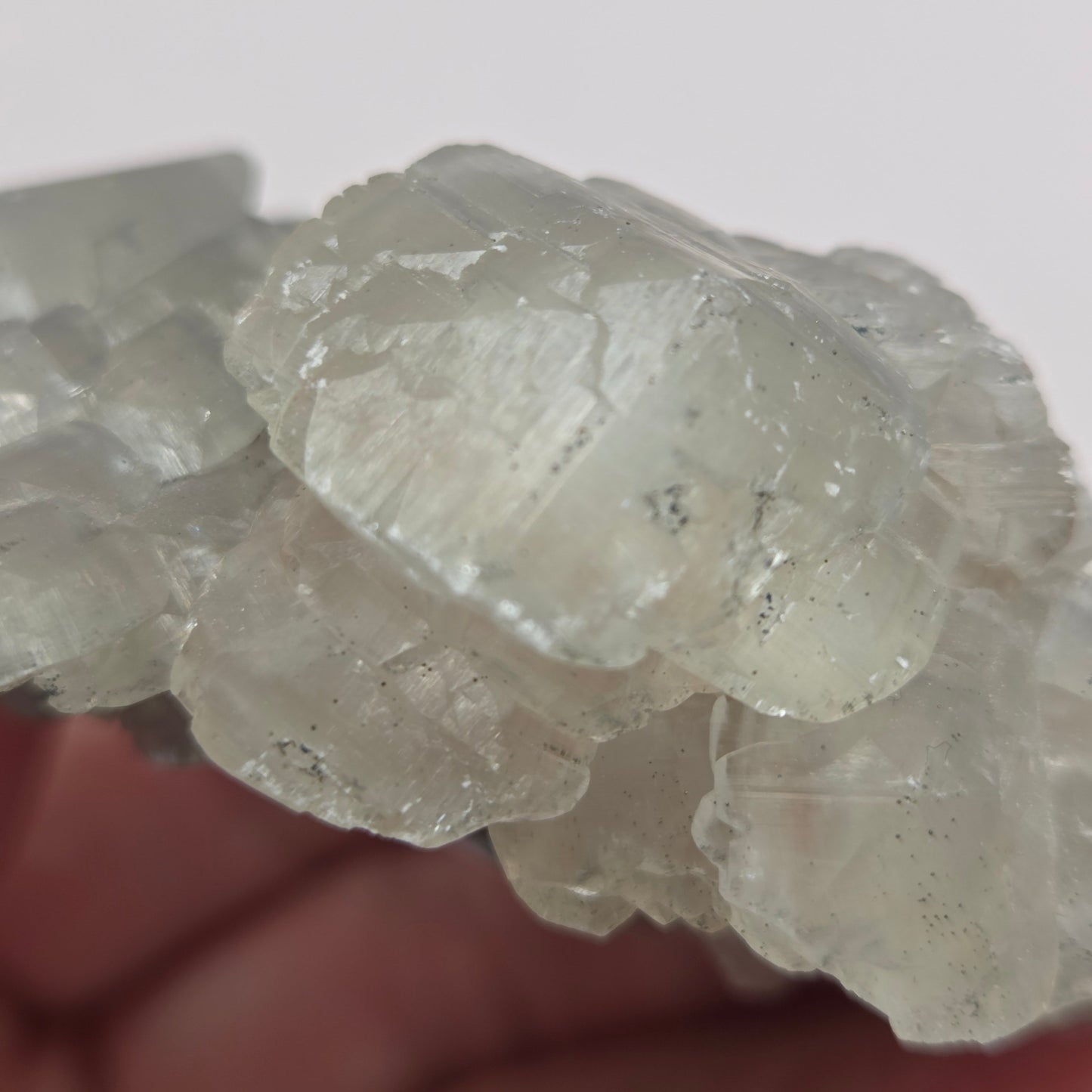 A rough, unpolished Money Calcite mineral from Hubei, China, with a translucent appearance and crystal-like formations.