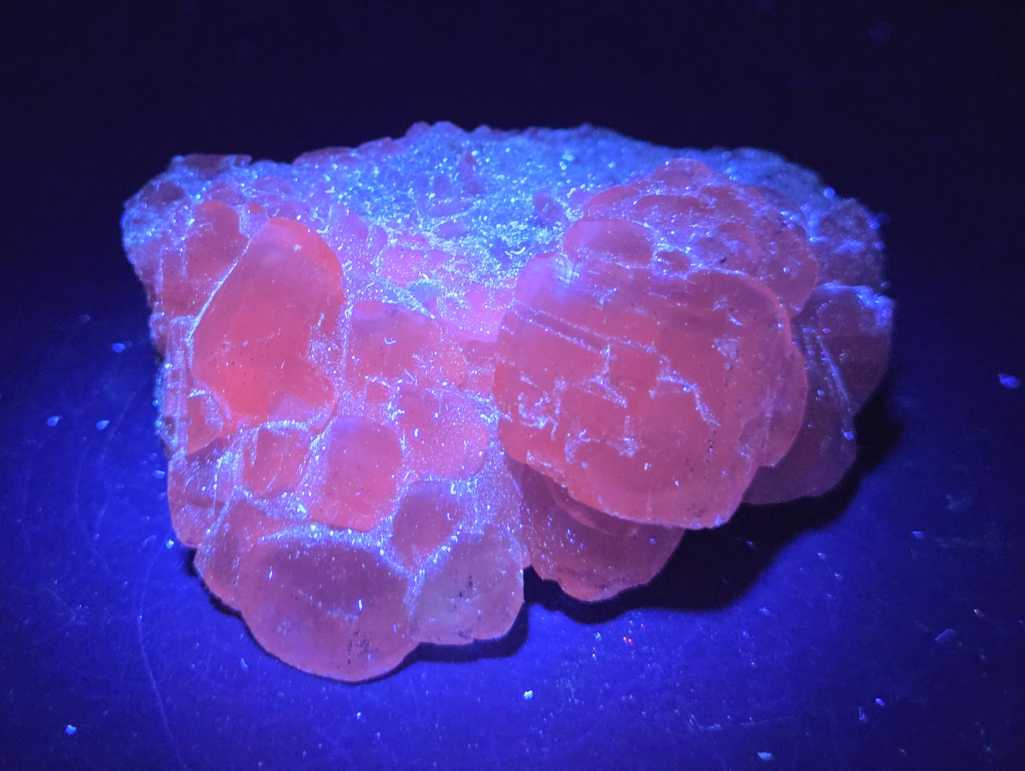 A rough, unpolished Money Calcite mineral from Hubei, China, with a translucent appearance and crystal-like formations under UV light