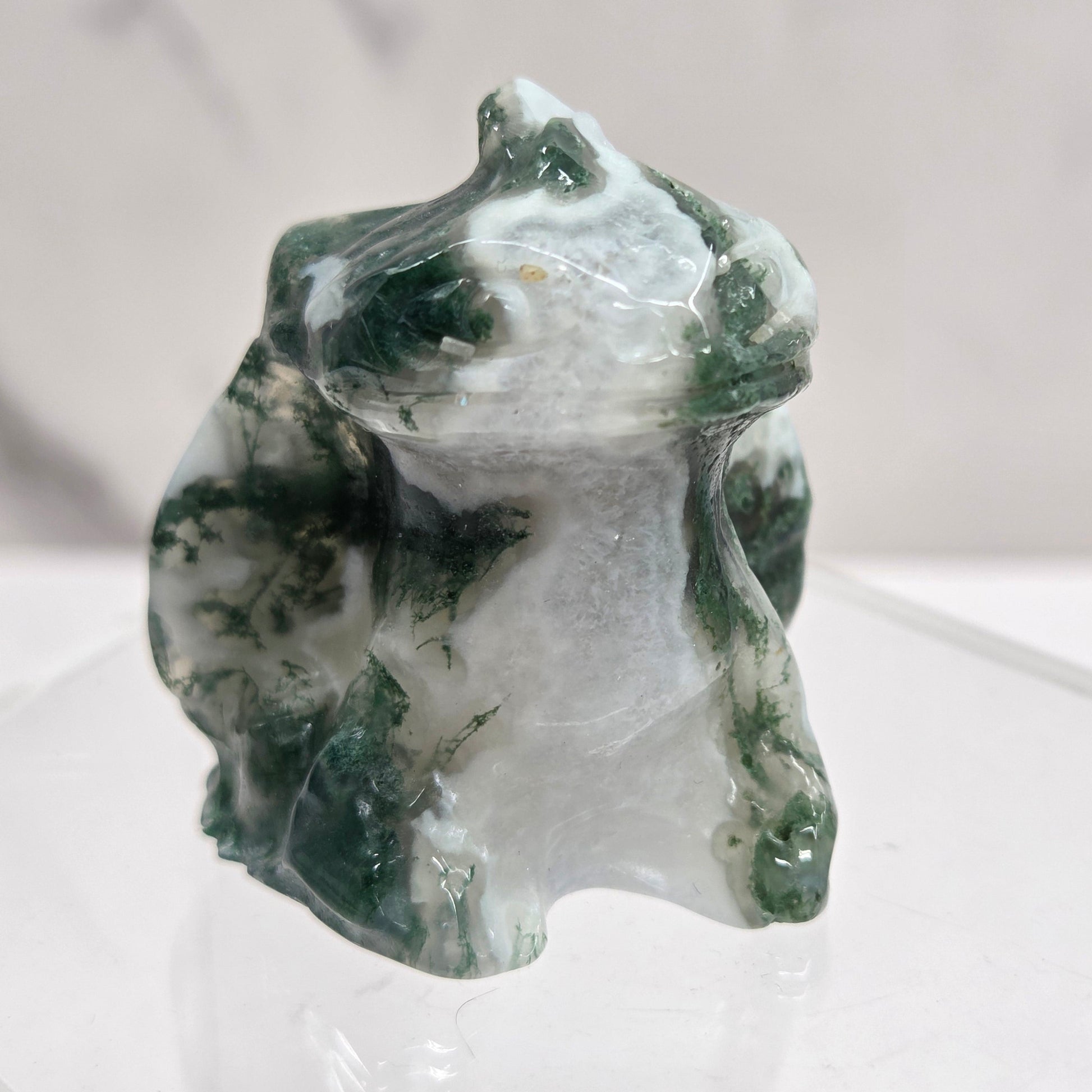 Carved Toothless Moss Agate carving with green and white patterns on a white background