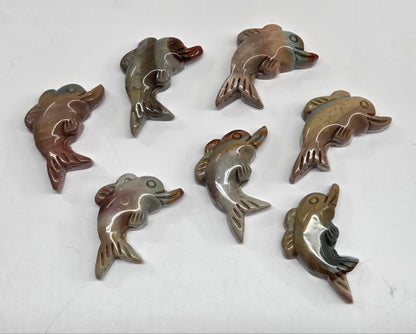 Collection of mini Alashan Agate multi-colored dolphin carvings on a white background