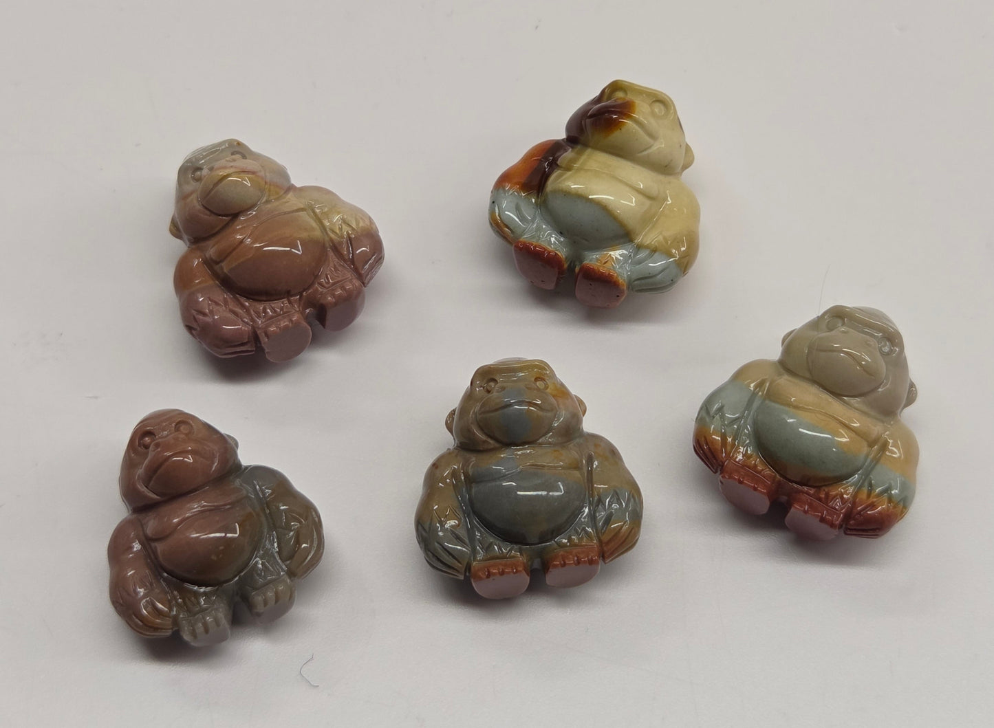 Collection of mini Alashan Agate multi-colored gorilla carvings on a white background