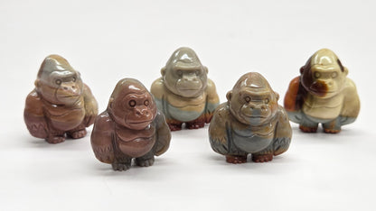 Collection of mini Alashan Agate multi-colored gorilla carvings on a white background