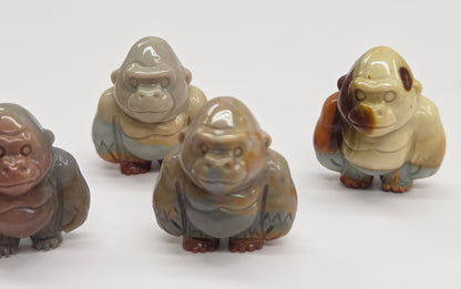 Collection of mini Alashan Agate multi-colored gorilla carvings on a white background