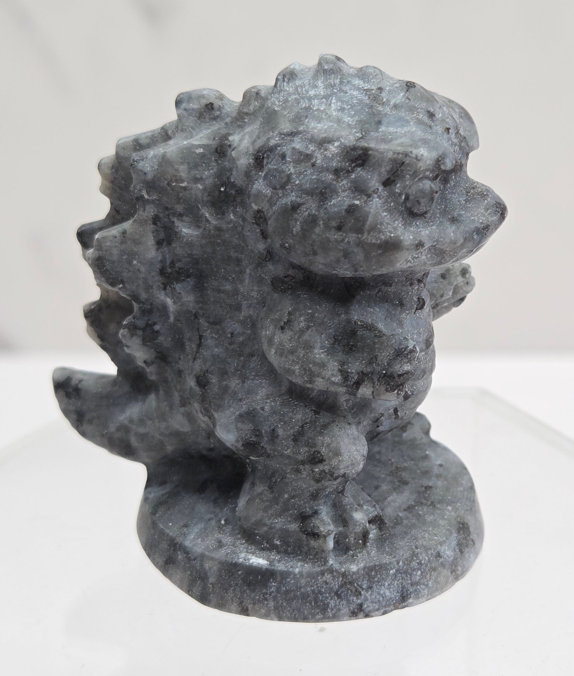 Larvikite Godzilla carving on a white background