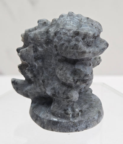 Larvikite Godzilla carving on a white background