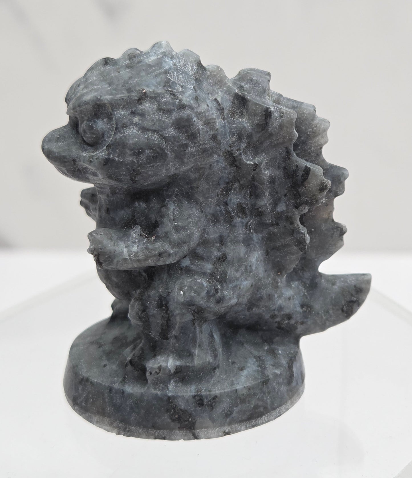 Larvikite Godzilla carving on a white background