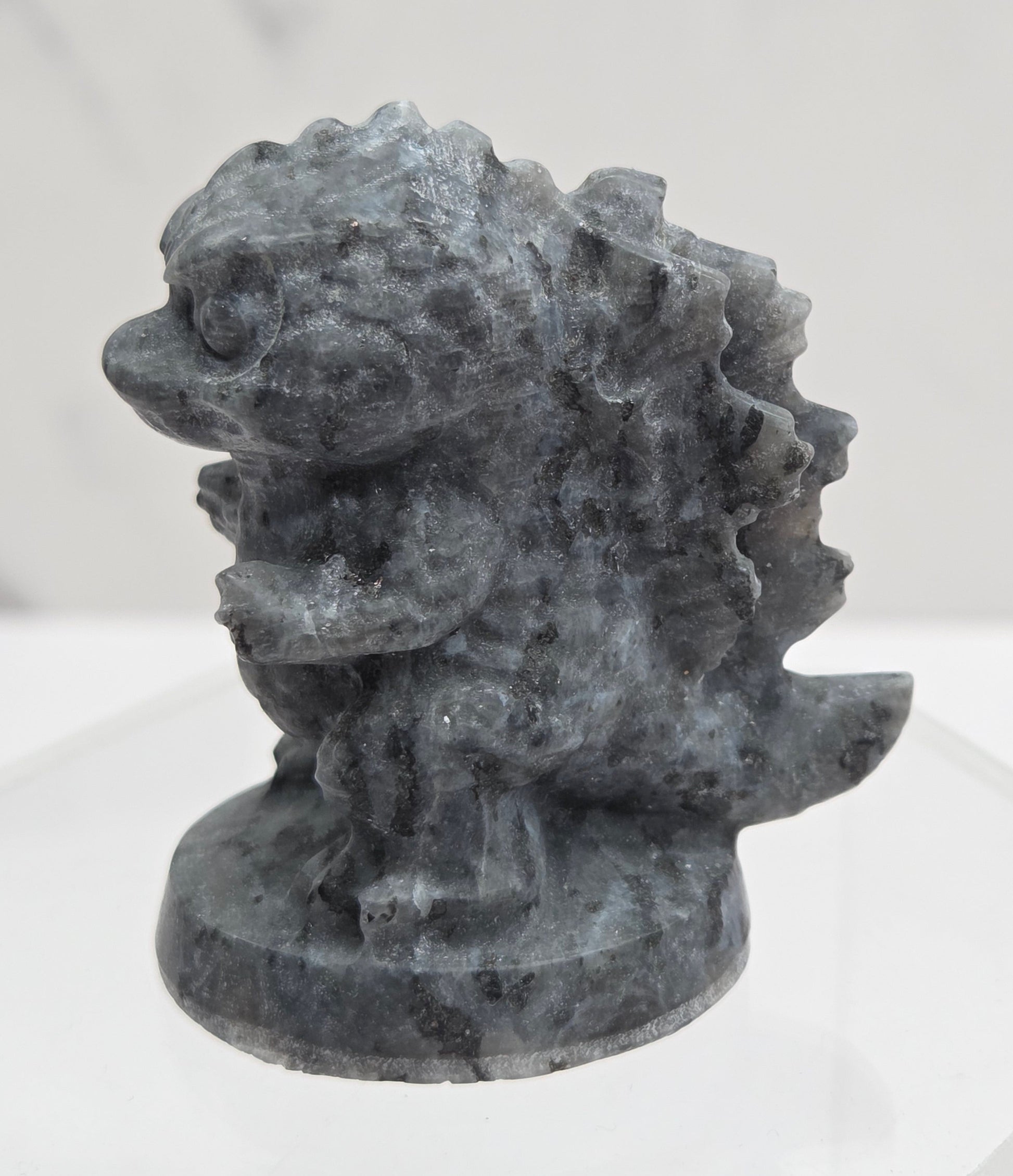 Larvikite Godzilla carving on a white background