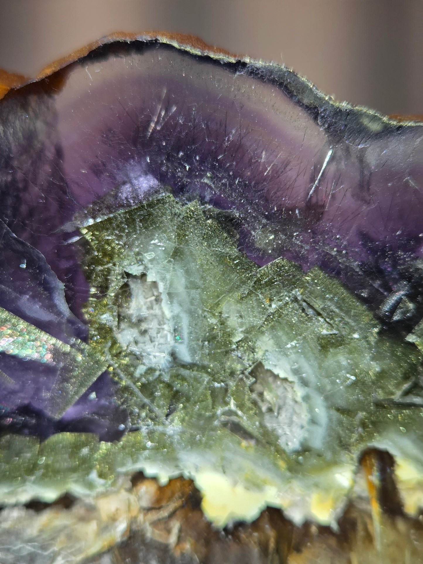 Close-up of a crystal with purple and green colors on a blurred background