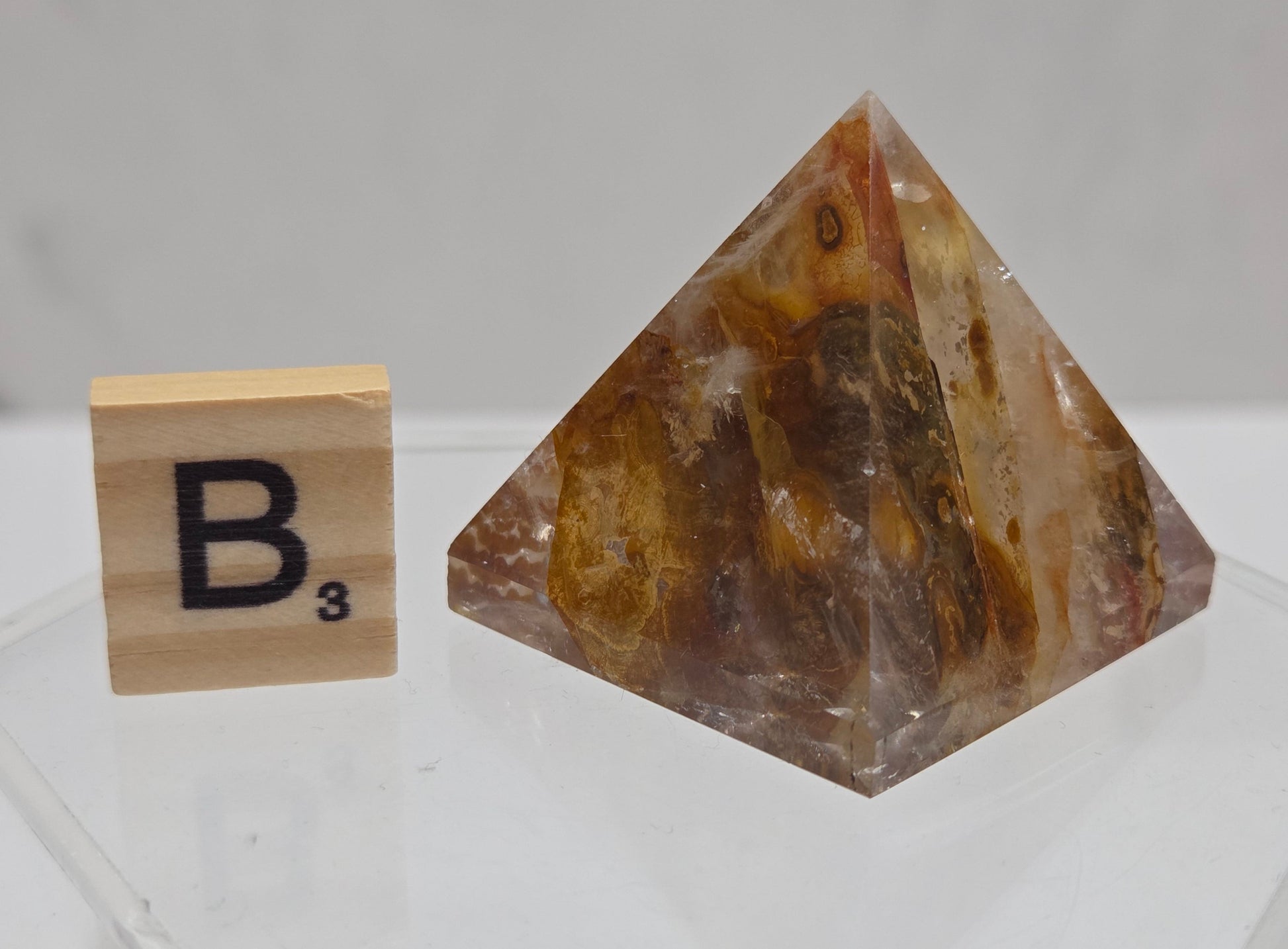 Polished stone crystal on a stand with a label in the background