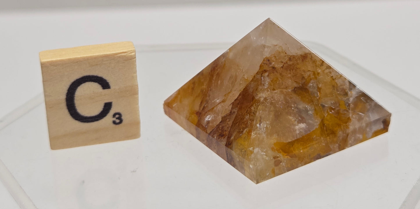 Crystal pyramid and wooden block with 'C3' on a white background