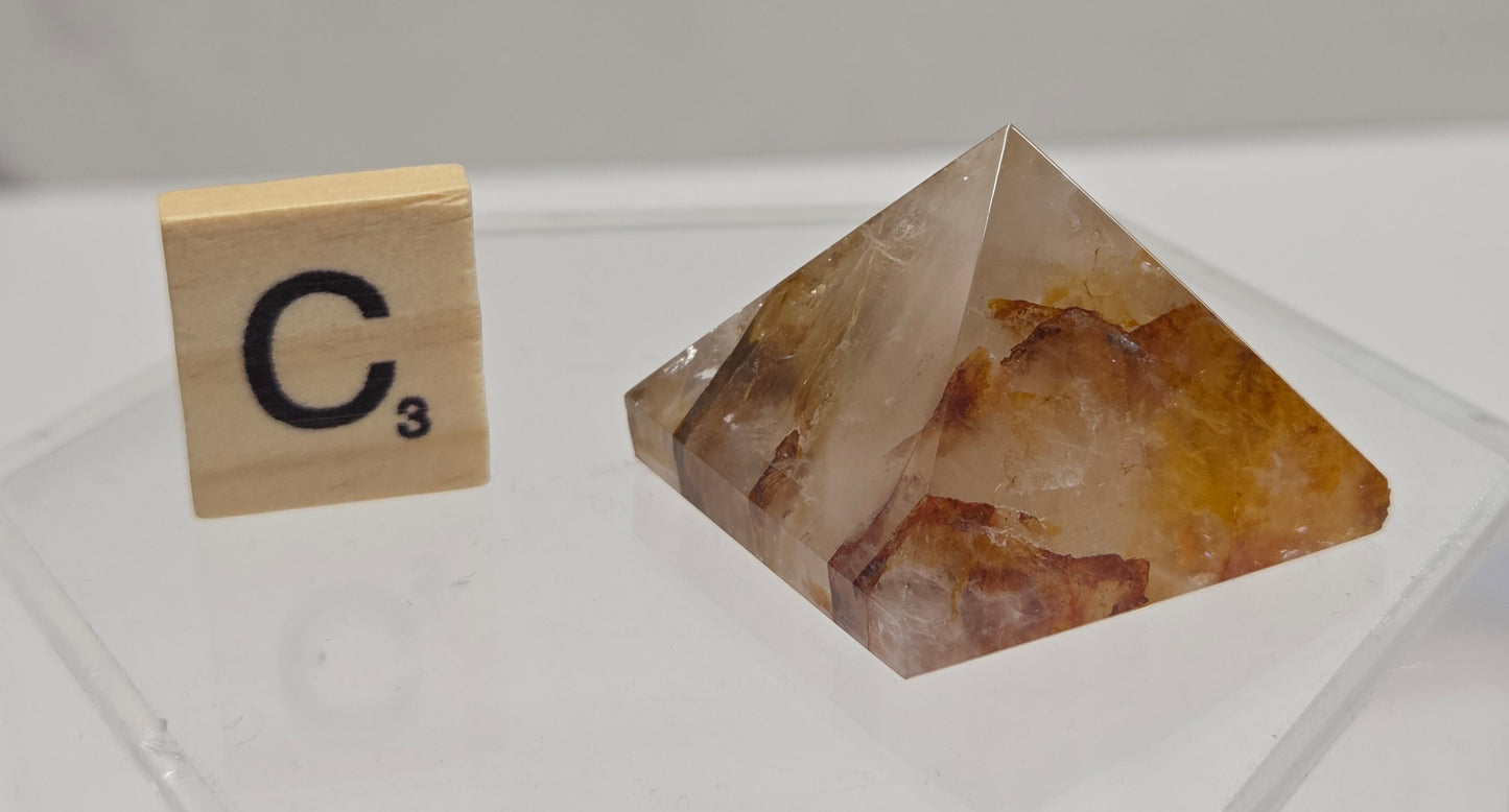 Crystal pyramid and wooden block with 'C3' on a white surface