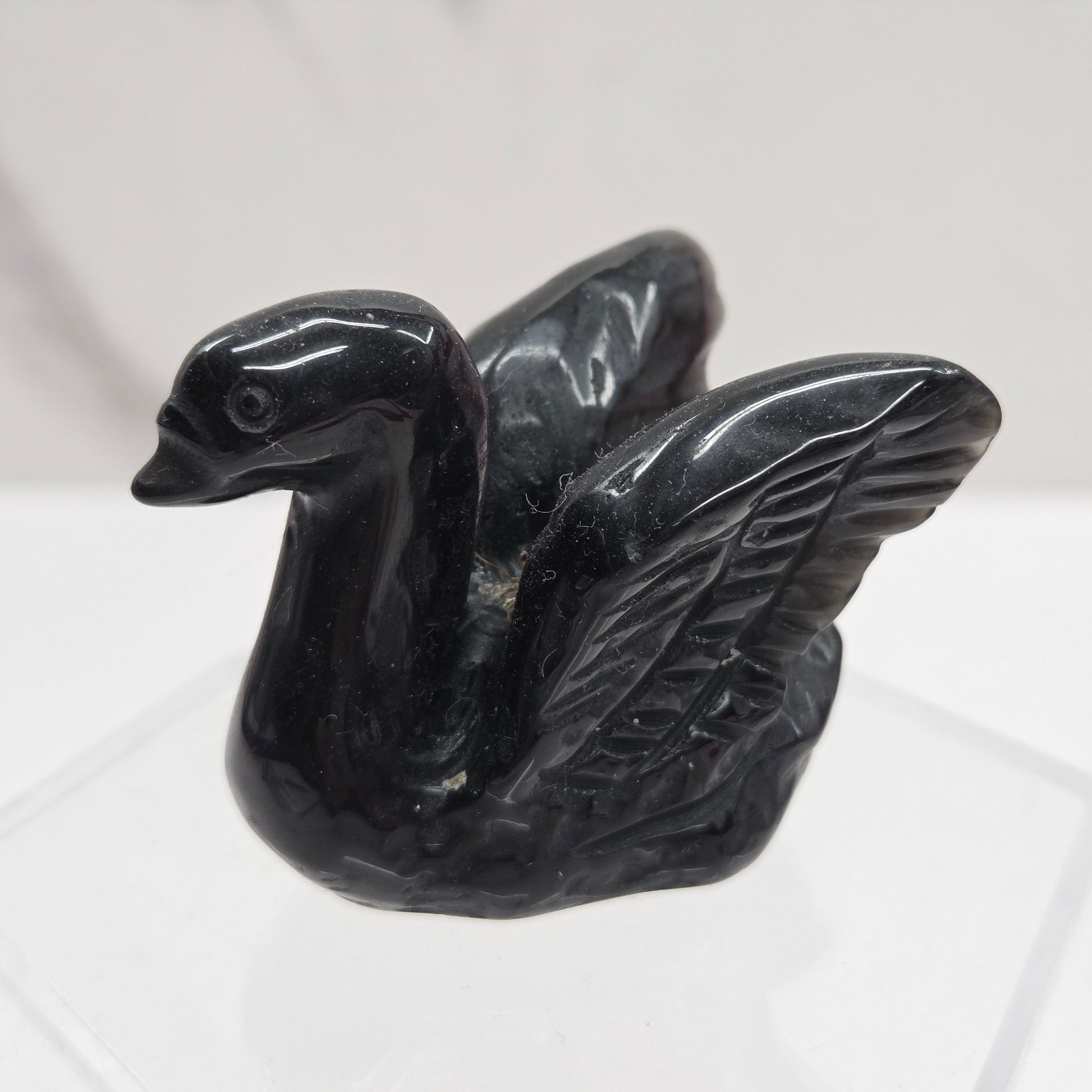 Black Obsidian crystal sculpture of a swan on a white background