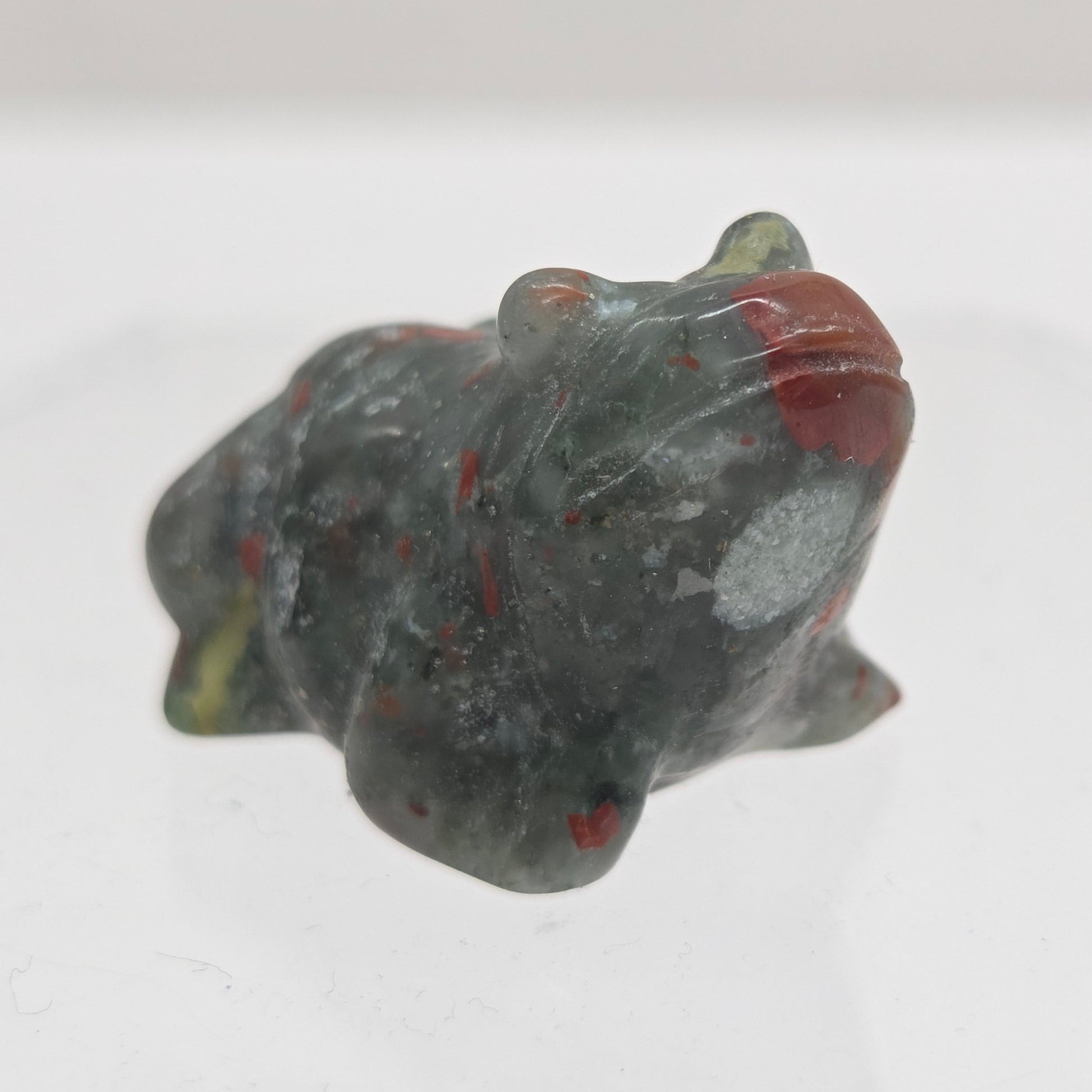African Bloodstone frog carving on a white background